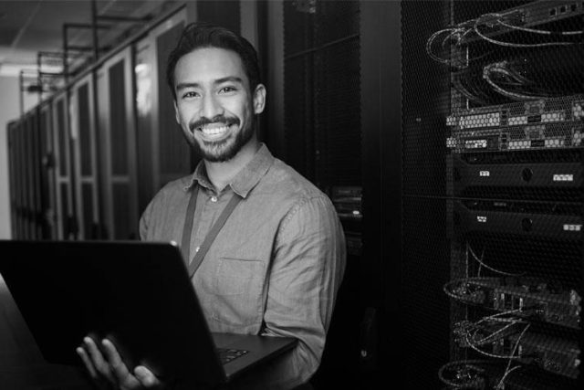 Smiling male security specialist with laptop